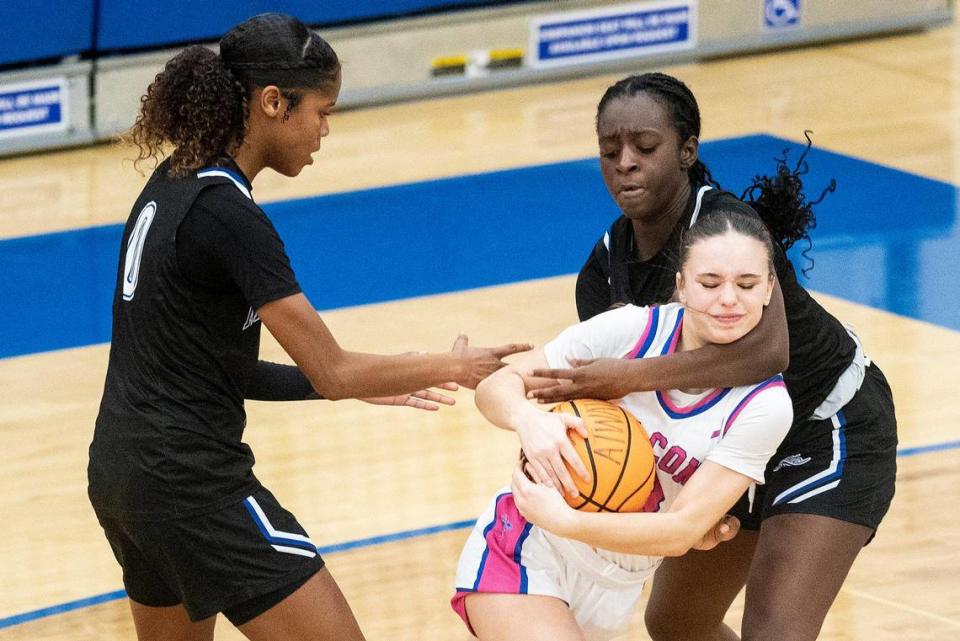 Atwater sophomore Saige Harcksen (3) battles for possession of the ball with Mountain House junior Jariah Indalecio (0) and Mountain House senior Niara Mangrum (1) during a CIF Sac-Joaquin Section Division 2 playoff game at Atwater High School in Atwater, Calif., on Wednesday, Feb. 14, 2024. The Falcons beat the Mustangs 95-59.