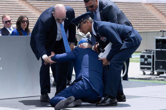 President Joe Biden is helped up after falling during the graduation ceremony at the United States Air Force Academy, just north of Colorado Springs in El Paso County, Colorado, on June 1, 2023.