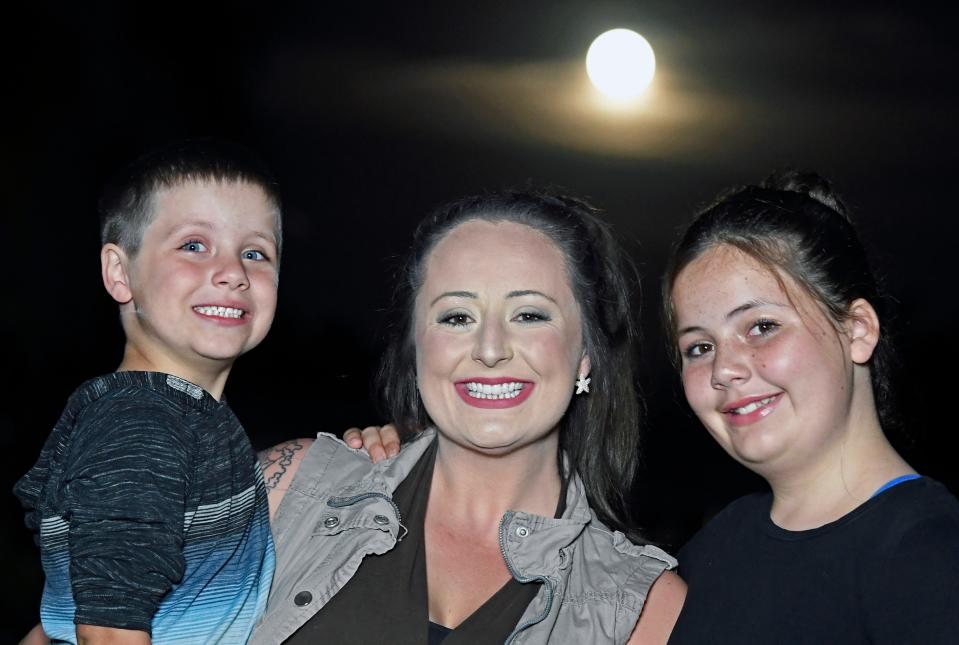 Brooklyn Dean with Ezra, 5, and Alayna, 10, of North Port. Celestial events, like the full moon behind them, are one of Brooklyn's favorite things to follow.