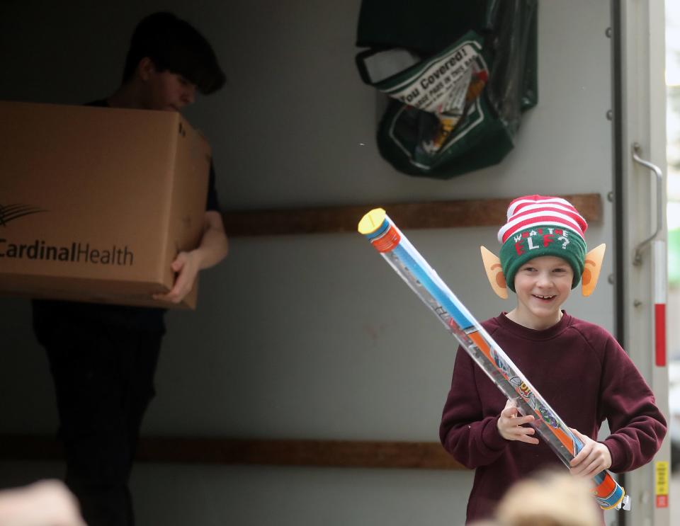 Kidzz Helping Kidzz’s Noah Darner, 8, grins as he carries a loose toy out of the U-haul truck of donated toys at St. Michael Medical Center in Silverdale on Thursday, Dec. 21, 2023.