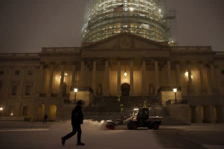 Workers clear falling snow from the East Front of the U.S. Capitol in Washington January 22, 2016. REUTERS/Jonathan Ernst