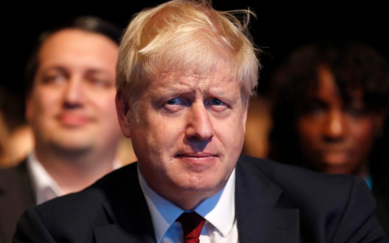 Prime Minister Boris Johnson listens to Sajid Javid, Chancellor of the Exchequer, as he delivers his speech at the Conservative Party Conference in Manchester - AP