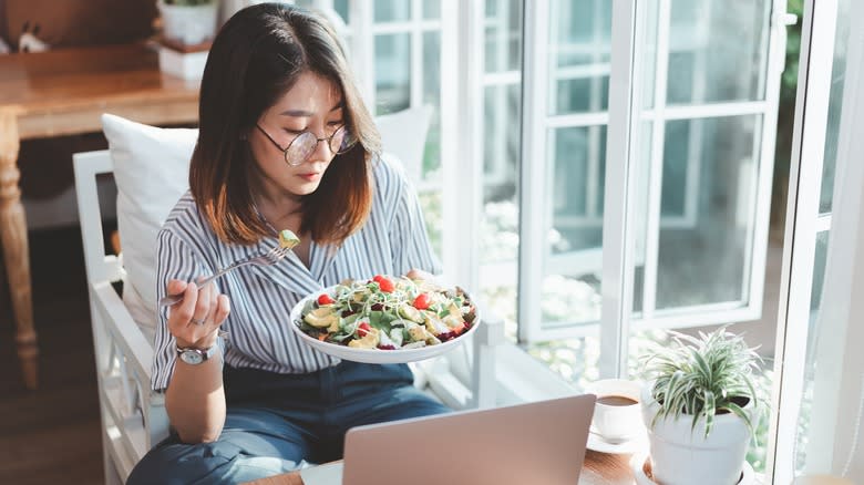 woman eating at computer