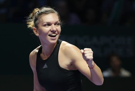 Simona Halep of Romania celebrates her win over Agnieszka Radwanska of Poland during their WTA Finals singles semi-finals tennis match at the Singapore Indoor Stadium October 25, 2014. REUTERS/Edgar Su