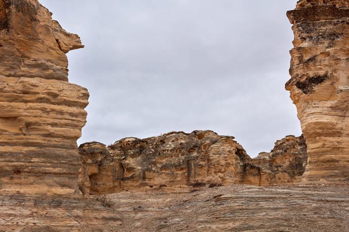 Nature Scenic of Eroded Rock Formations in front of Grey Overcast Sky in Castle Rock Badlands, Kansas