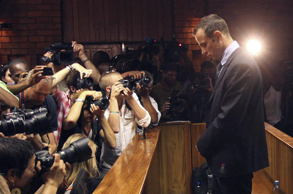 FILE - Photographers take pictures of Olympic athlete Oscar Pistorius as he appears at a bail hearing for the shooting death of his girlfriend Reeva Steenkamp, in Pretoria, South Africa, on Feb 22, 2013. Oscar Pistorius is due on Friday, Jan. 5, 2024 to be released from prison on parole to live under strict conditions at a family home after serving nearly nine years of his murder sentence for the shooting death of girlfriend Reeva Steenkamp on Valentine’s Day 2013. (AP Photo/Themba Hadebe, File)