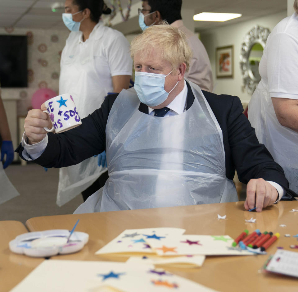 <p>Britain's Prime Minister Boris Johnson takes part in an activity, during a visit to Westport Care Home in Stepney Green, east London,  Tuesday, Sept. 7, 2021, ahead of unveiling his long-awaited plan to fix the broken social care system. (Paul Edwards/Pool Photo via AP)</p>
