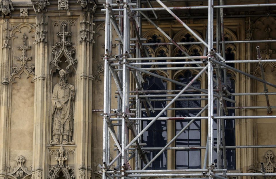 FILE - A detailed figure near scaffolding on Britain's Houses of Parliament as it undergoes restoration work to repair the crumbling building, in London, Wednesday, April 17, 2019. British lawmakers are warning that the country's Parliament building is at “real and rising” risk of destruction. The House of Commons Public Accounts Committee said Parliament is “leaking, dropping masonry and at constant risk of fire,” as well as riddled with asbestos. The committee said Wednesday, May 17, 2023 that “there is a real and rising risk that a catastrophic event will destroy” the building before long-delayed restoration work is done. (AP Photo/Kirsty Wigglesworth, File)