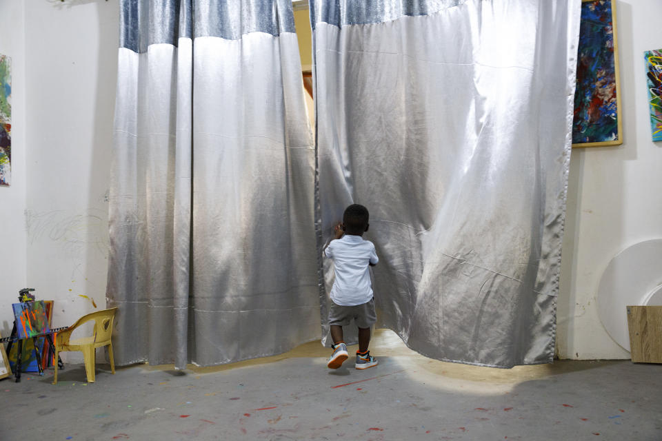 Ace-Liam Nana Sam Ankrah, who will turn two in July, exits his work space at his mother's art gallery in Accra, Ghana, Monday, May 27, 2024. Ankrah has set the record as the world's youngest male artist. His mother, Chantelle Kukua Eghan, says it all started by accident when her son, who at the time was 6 months old, discovered her paints. (AP Photo/Misper Apawu)