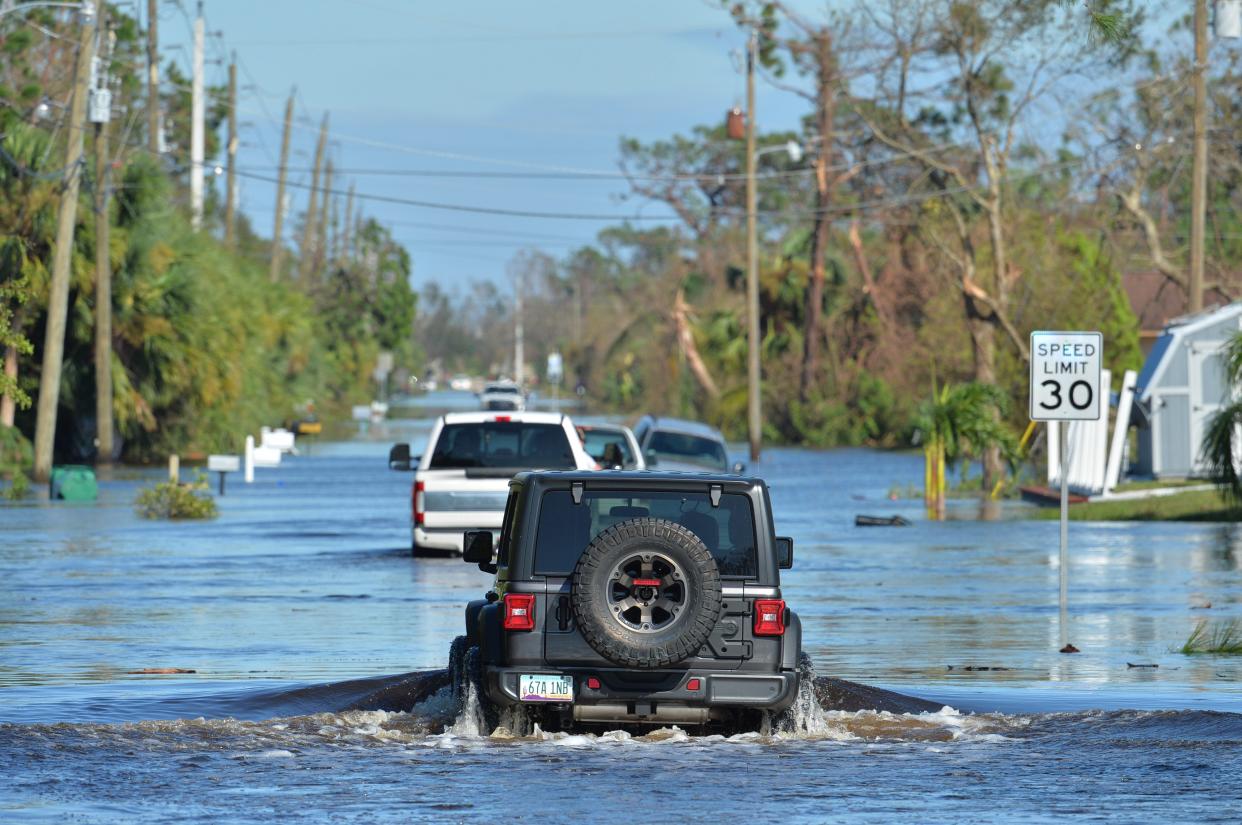 People in four-wheel drive vehicles navigate a flooded Prospect Avenue in Englewood, Florida as homeowners attempted to get to their homes following Hurricane Ian on Thursday, Sept. 29, 2022. The Federal Emergency Management Agency has developed updated maps documenting areas of Sarasota County deemed vulnerable to flooding. The maps, which determine which properties are required to have flood insurance, take effect in March.
