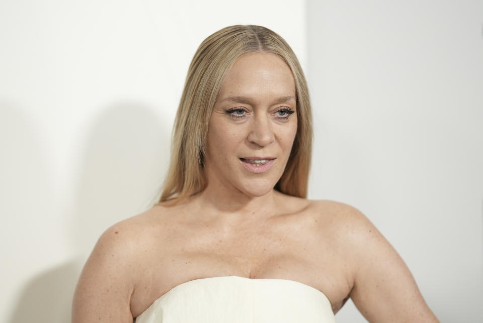 Chloë Sevigny posing in an elegant, strapless white gown