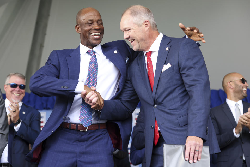 Hall of Fame inductees Fred McGriff, left, and Scott Rolen shake hands during a National Baseball Hall of Fame induction ceremony Sunday, July 23, 2023, at the Clark Sports Center in Cooperstown, N.Y. (AP Photo/Bryan Bennett)