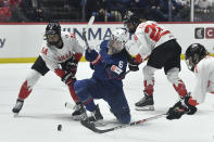 United States' Rory Guilday, center, tries to shoot as she is defended by Canada's Renata Fast, left, and forward Emily Clark during the second period in the final at the women's world hockey championships in Utica, N.Y., Sunday, April 14, 2024. (AP Photo/Adrian Kraus)