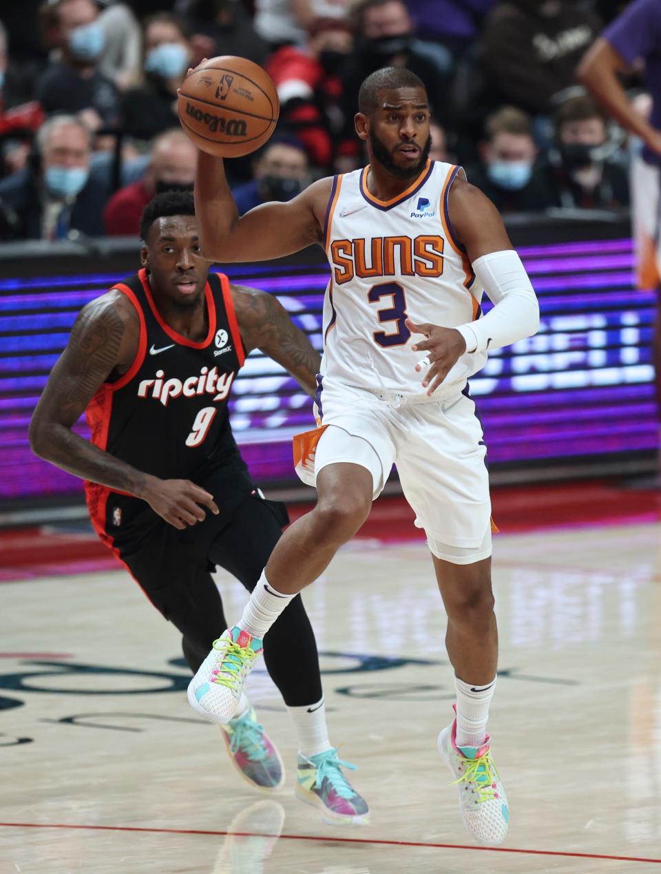 Phoenix Suns guard Chris Paul, right, passes the ball as Portland Trail Blazers forward Nassir Little, left, defends during the first half of an NBA basketball game in Portland, Ore., Tuesday, Dec. 14, 2021. (AP Photo/Steve Dipaola)