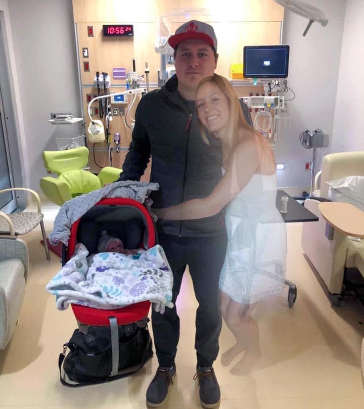 Picture of widow, Scott Jenkins taking his newborn daughter, Sydney, home for the first time, after his wife Aly Jenkins died during labor. Aly Jenkins has been added into the photo with photoshop