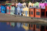 <p>A strip of color-punched houses in Santa Cruz contrasts with the brown landscape.</p>