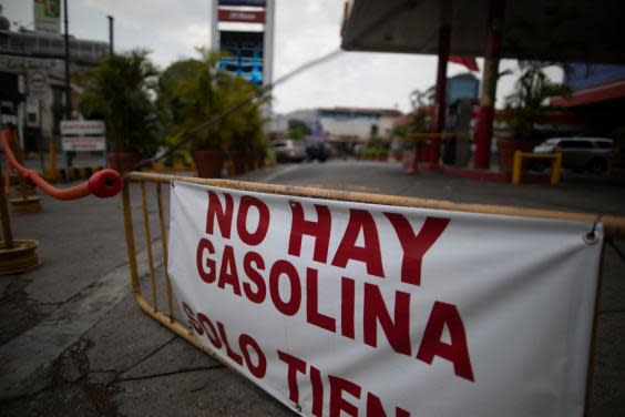 A banner reads “there is no gasoline” outside a closed fuel station in Caracas, Venezuela (AP)