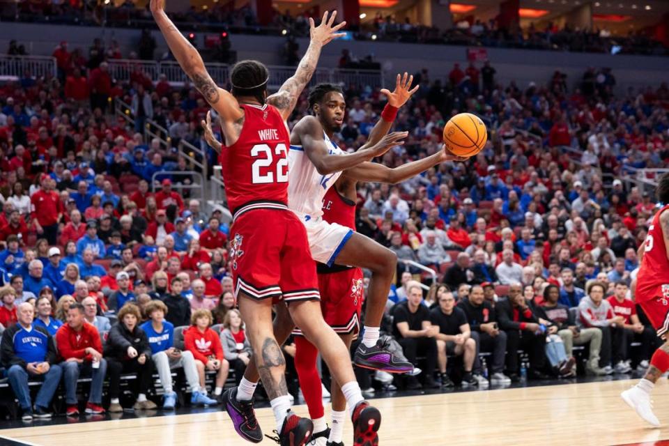Kentucky Wildcats guard Antonio Reeves (12) drives to the basket against Louisville Cardinals guard Tre White (22) during the game at the KFC Yum! Center in Louisville, Ky, Friday, December 21, 2023.