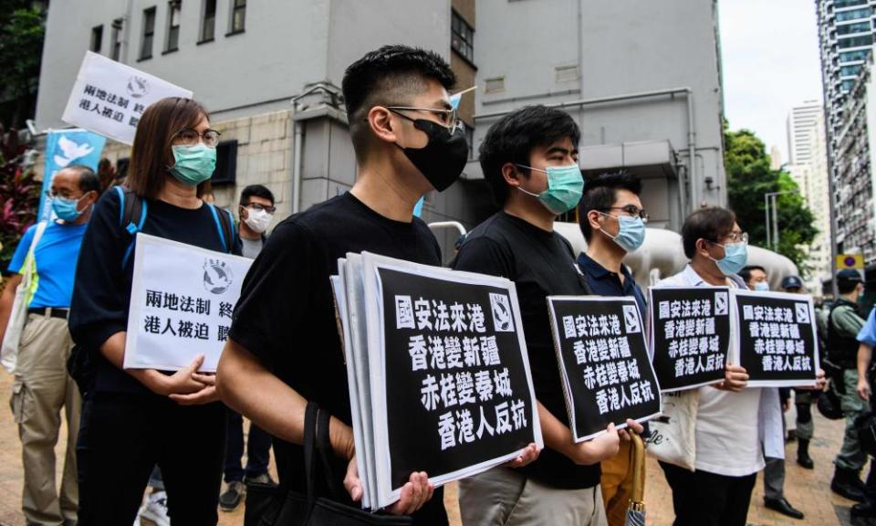 Pro-democracy protesters hold placards as they march from outside the Western Police Station to the Chinese Liaison Office in Hong Kong on 22 May.