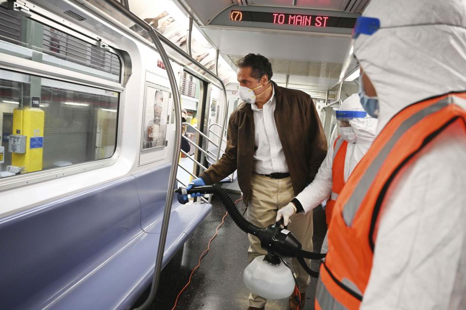 In this photo provided by the Office of Governor Andrew M. Cuomo, New York Gov. Cuomo tries out a spraying device which is part of a three-step disinfecting process of a New York City subway car at the Corona Maintenance Facility in the Queens borough of of New York, Saturday, May 2, 2020. Cuomo announced on Thursday April 30, that New York City is shutting down its subway system each day from 1 a.m. to 5 a.m. to increase cleaning of trains and stations during the coronavirus crisis. (Kevin P. Coughlin/Office of Governor Andrew M. Cuomo via AP)