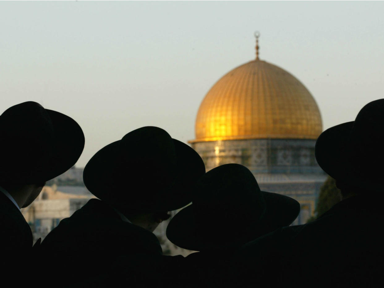 Ultra-Orthodox Jews look at the Dome of the Rock, one of the holiest sites for Muslims, in Jerusalem on August 8, 2002: Reuters