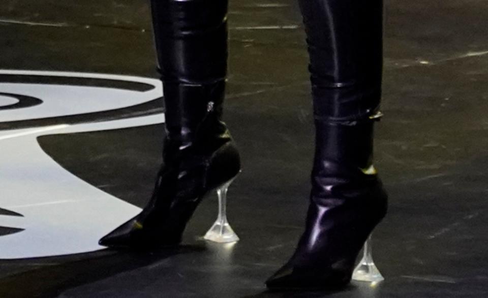 A closer look at Christina Aguilera wearing black leather boots featuring a timeless pointed toe and transparent, pyramid-shaped heels. - Credit: AP