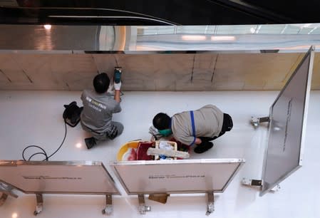 Workers clean graffiti at New Town Plaza in Sha Tin, Hong Kong, China