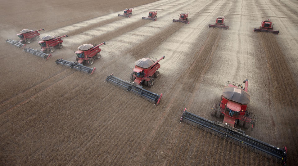 FILE - In this March 27, 2012 file photo, workers use combines to harvest soybeans in Tangara da Serra, State of Mato Grosso, Brazil. For more than a decade, Brazil has been one of the developing world's great hopes, outpacing the growth of Western Europe and the U.S. Many even predicted it would soon become an economic superpower, but now analysts generally believe the big boom is past. Prices for exported commodities such as iron ore and soybeans are drooping due to concerns over Chinese growth. (AP Photo/Andre Penner, File)