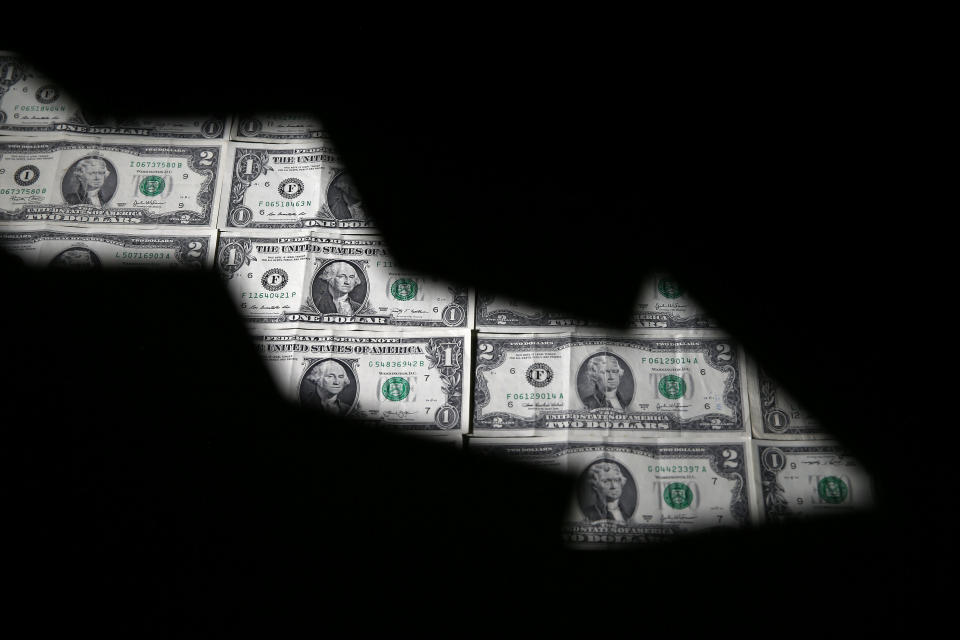 U.S. dollar banknotes are seen through a printed stock graph in this illustration taken February 7, 2018. REUTERS/Dado Ruvic/Illustration