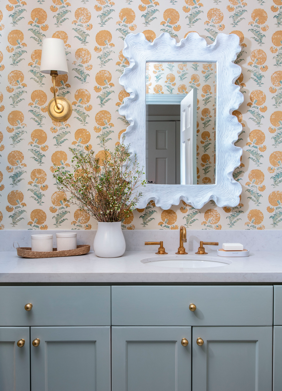 wallpapered bathroom with blue vanity