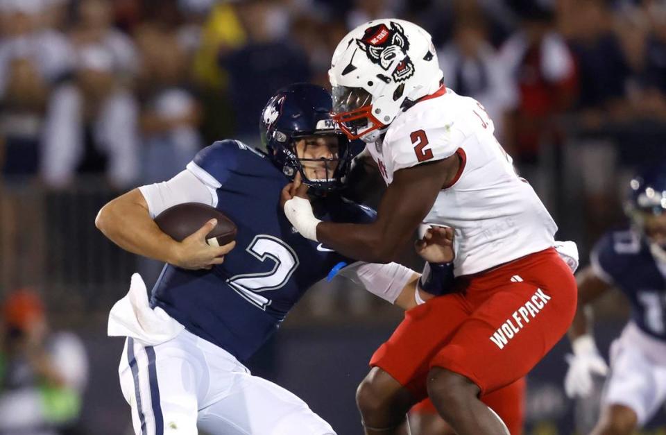 N.C. State linebacker Jaylon Scott (2) tackles Connecticut quarterback Joseph Fagnano (2) during the first half of N.C. State’s game against UConn at Rentschler Field in East Hartford, Conn. Thursday, August 31, 2023.