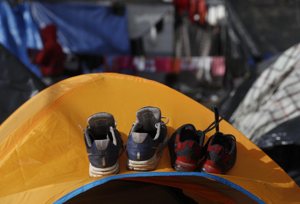 Shoes air out on top of a tent as migrants camp in the street outside a sports complex shelter that authorities were trying to close, in Tijuana, Mexico, Saturday, Dec. 1, 2018. By Saturday afternoon, most of the thousands of migrants who had been camped out at the sports complex had agreed to move to the new, more distant shelter. Others decided to try their luck camping in the street near the former shelter or look for their own accommodation.(AP Photo/Rebecca Blackwell)