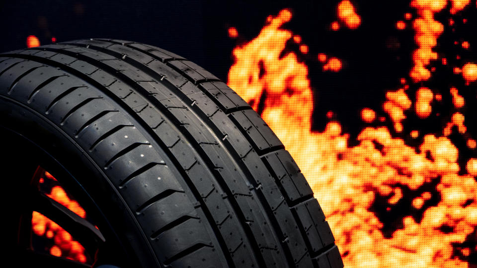 Close-up shot of a car tire, which appears to be on fire.