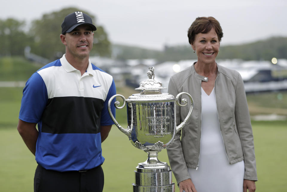FILE - Brooks Koepka poses for a photo with PGA president Suzy Whaley after winning the PGA Championship golf tournament, Sunday, May 19, 2019, at Bethpage Black in Farmingdale, N.Y. Whaley in 2018 became the first woman to be PGA president, an example of women taking higher roles in golf the last 20 years. (AP Photo/Julio Cortez, File)