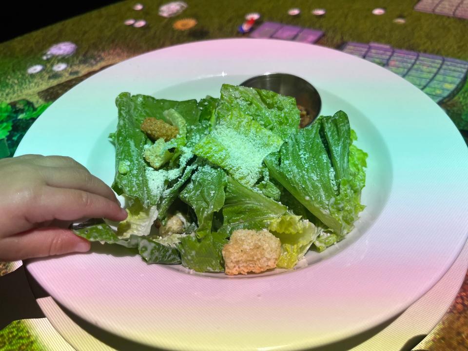 A Ceasar salad on a white plate at Le Petit Chef