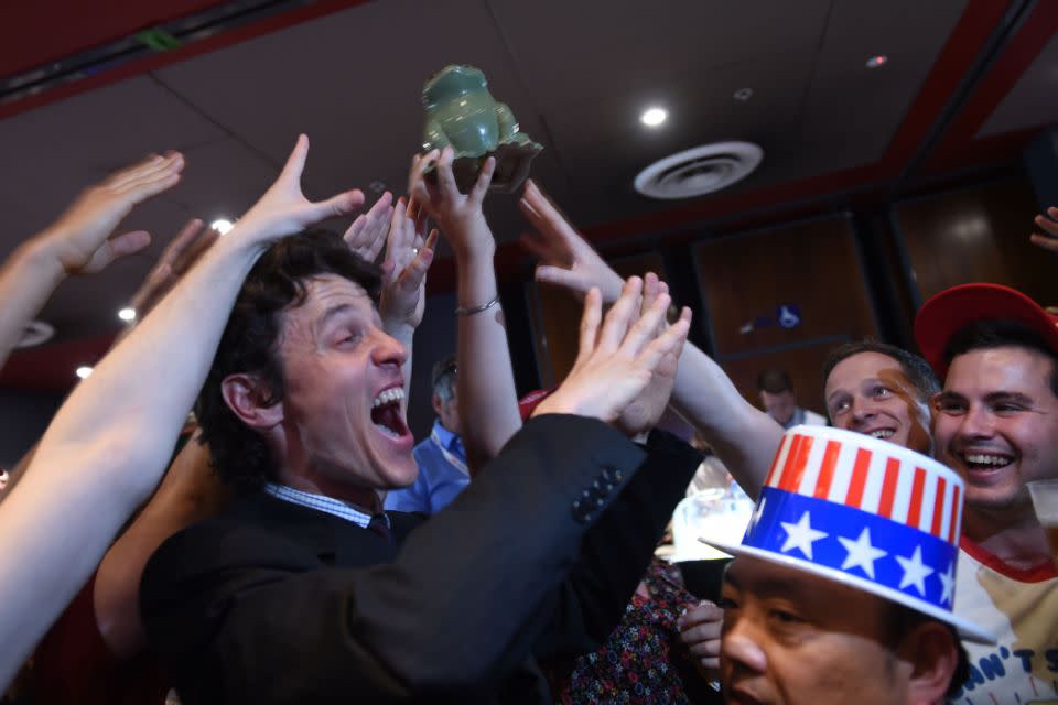 University of Sydney students cheer and hold up a frog while watching the election. Photo: AAP