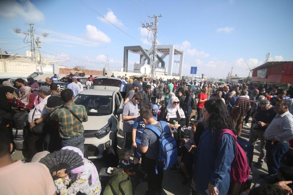 Palestinians wait to cross to the Egyptian side at Rafah border, Gaza Strip, Monday, Oct. 16, 2023.