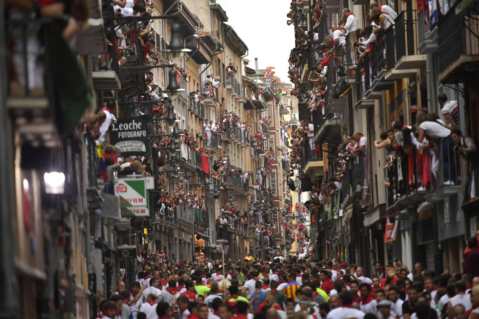 <p>Revellers wait for fighting bulls from the Victoriano del Rio ranch during the 6th day of the running of the bulls at the San Fermin Festival in Pamplona, northern Spain, July 12, 2018. (Photo: Alvaro Barrientos/AP) </p>
