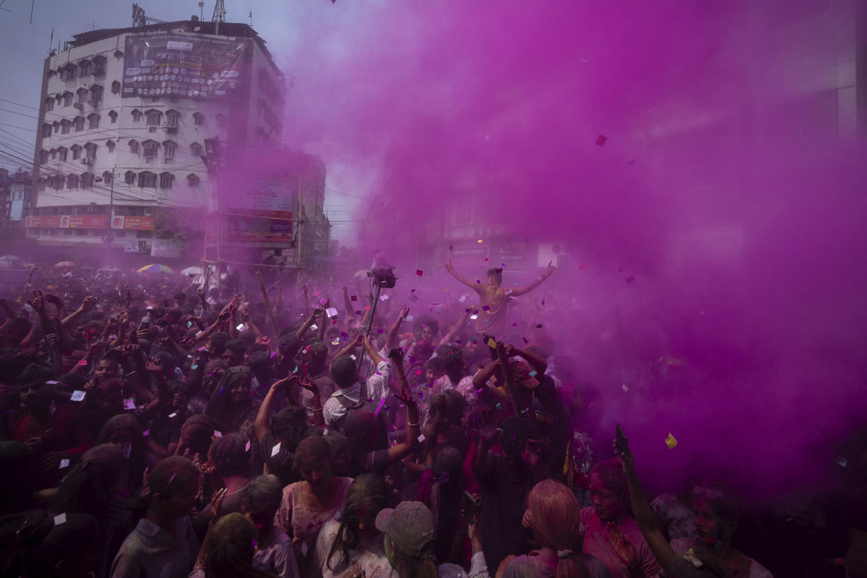 People celebrate Holi, the festival of colors on a street in Guwahati, India, Wednesday, March 8, 2023.Millions of Indians on Wednesday celebrated the ''Holi" festival, dancing to the beat of drums and smearing each other with green, yellow and red colors and exchanging sweets in homes, parks and streets. Free from mask and other COVID-19 restrictions after two years, they also drenched each other with colored water. (AP Photo/Anupam Nath)