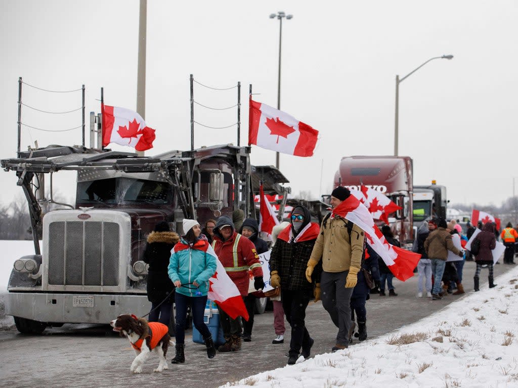 Supporters of the Freedom Convoy of truckers driving from British Columbia to Ottawa in protest against a Covid-19 vaccine mandate gather near a highway overpass outside of Toronto, Ontario (Cole Burston/AFP/Getty)