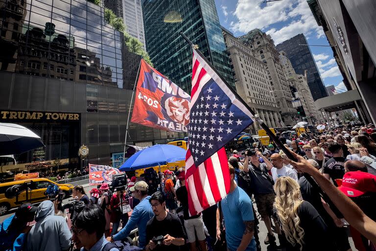 Un partidario del expresidente Trump ondea una bandera  invertida durante una manifestación frente a la Torre Trump