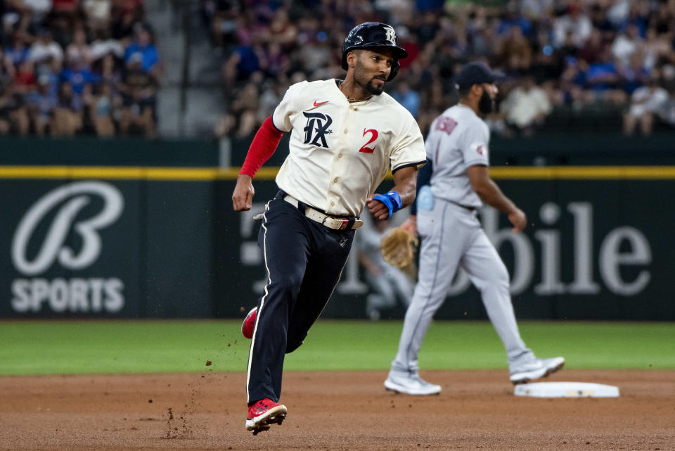 Texas Rangers' Marcus Semien (2) sprints toward third base on a fielder's choice in the bottom of the first inning in a baseball game against the Cleveland Guardians in Arlington, Texas, Saturday, July 15, 2023. (AP Photo/Emil T. Lippe)