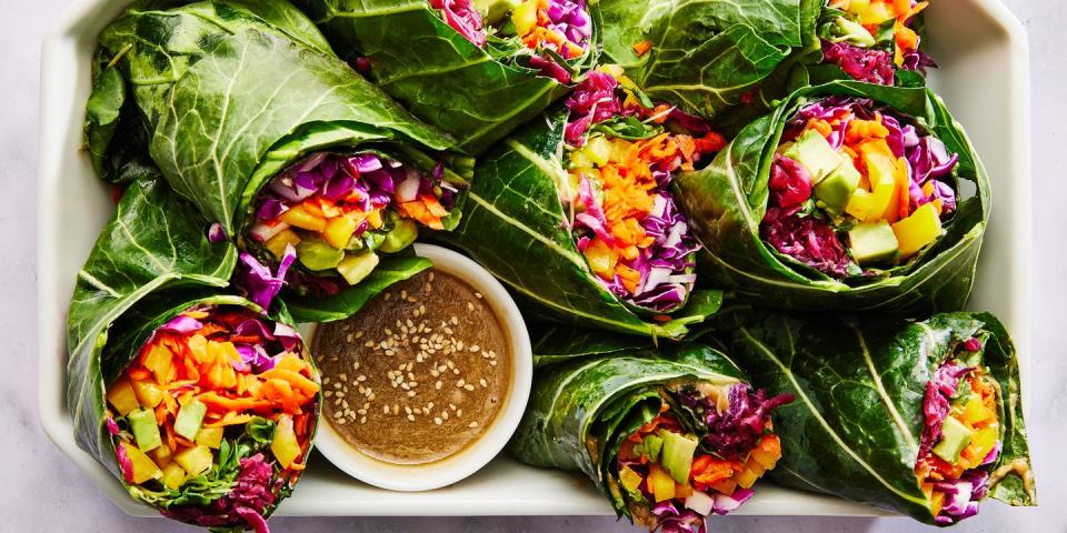 collard green wrap filled with shredded purple cabbage, grated carrots, yellow bell pepper, avocado, alfalfa sprouts and red sauerkraut