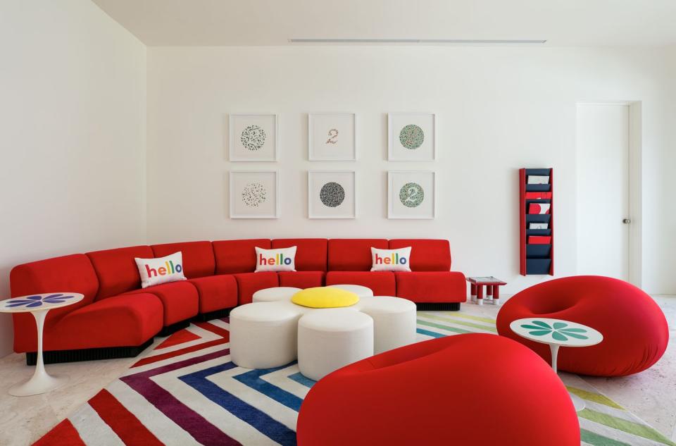 2) Vibrant red seating injects personality into the white living space.