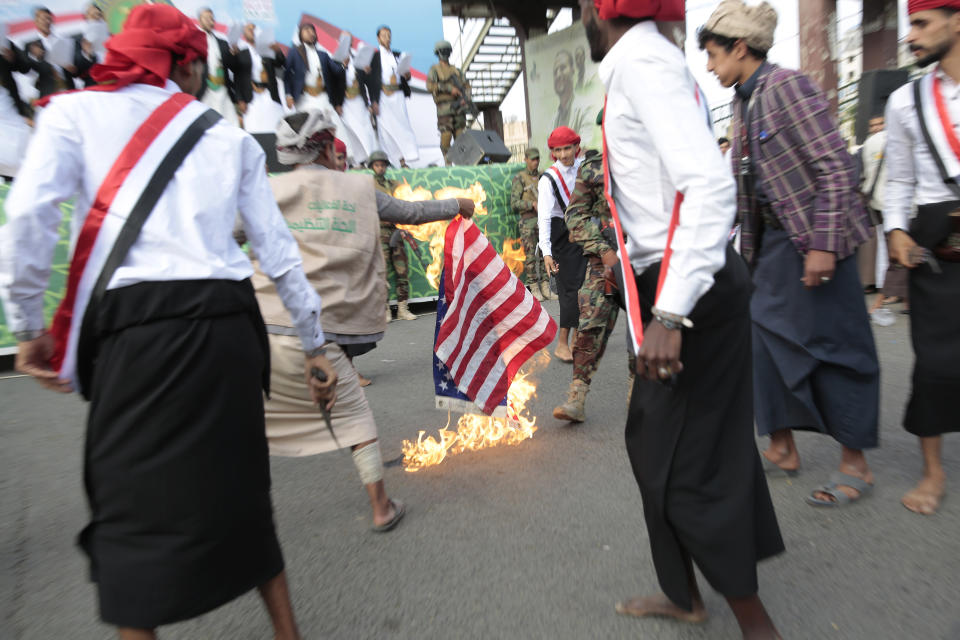 FILE - Houthi supporters burn a representation of the U.S. flag during a rally to mark the seventh anniversary of the Houthis' takeover of the Yemeni capital, in Sanaa, Yemen, Tuesday, Sept. 21, 2021. For years, the Houthi rebels controlling northern Yemen have chanted slogans at their mass rallies calling for the destruction of Israel. But they never joined any conflict beyond the confines of their own country’s civil war or nearby in the Arabian Peninsula. The Iranian-backed Shiite Muslim force has launched at least six drone and missile attacks toward southern Israel since the Israel-Hamas war began on Oct. 7. (AP Photo/Hani Mohammed, File)