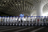 Airport staff push trollies at Chhatrapati Shivaji International Airport after domestic flights resume operations after nearly two-month lockdown amid the COVID-19 pandemic in Mumbai, India, Monday, May 25, 2020. (AP Photo/Rajanish Kakade)