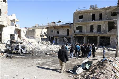 People gather at a site hit by what activists said was a barrel bomb dropped by forces loyal to Syria's President Bashar al-Assad in Haydariye district in Aleppo February 12, 2014. REUTERS/Hosam Katan