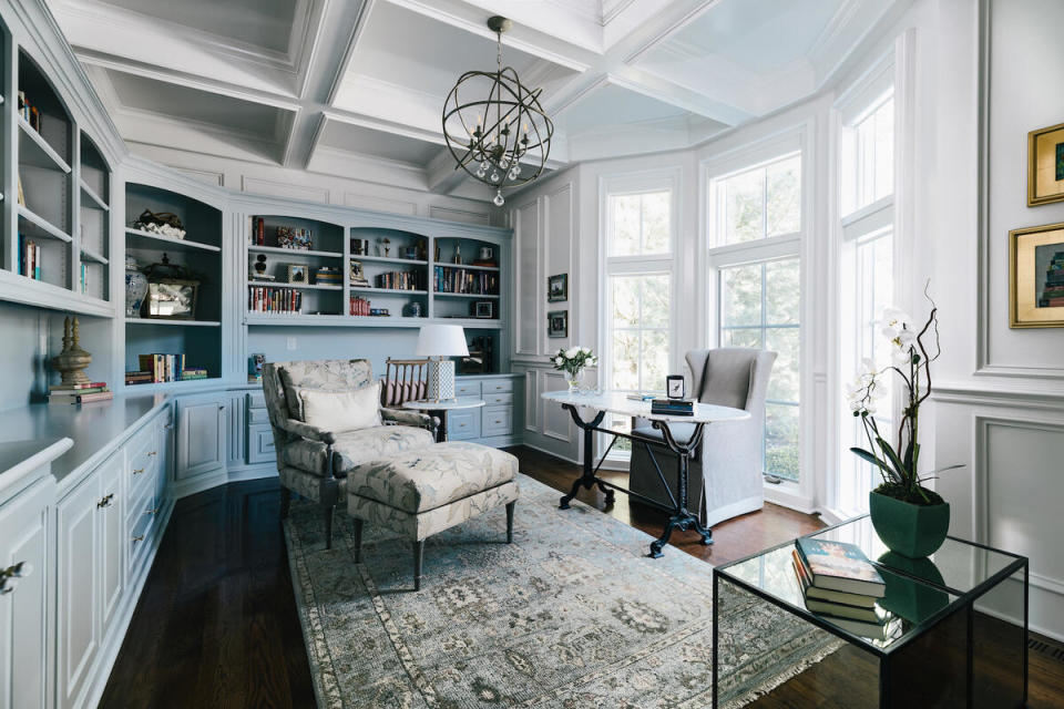 Soft blue built-in cabinetry offers ample book storage in an avid reader’s home office