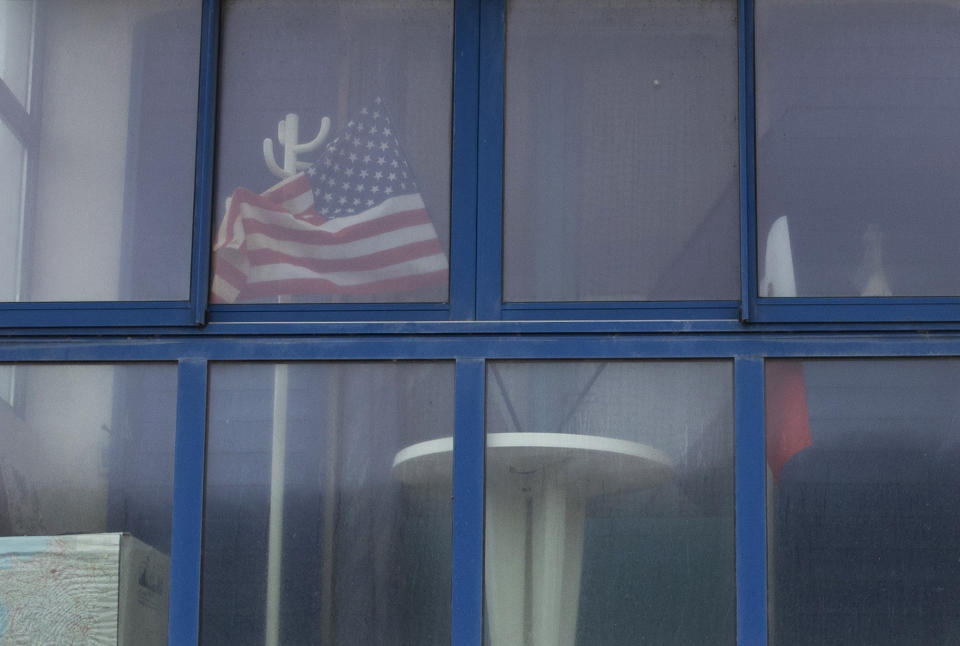 In this photo taken on Thursday, June 4, 2020, French and US flags sit behind a window in a beachfront house near Omaha Beach in Vierville-sur-Mer Normandy, France. In sharp contrast to the 75th anniversary of D-Day, this year's 76th will be one of the loneliest remembrances ever, as the coronavirus pandemic is keeping nearly everyone from traveling. (AP Photo/Virginia Mayo)