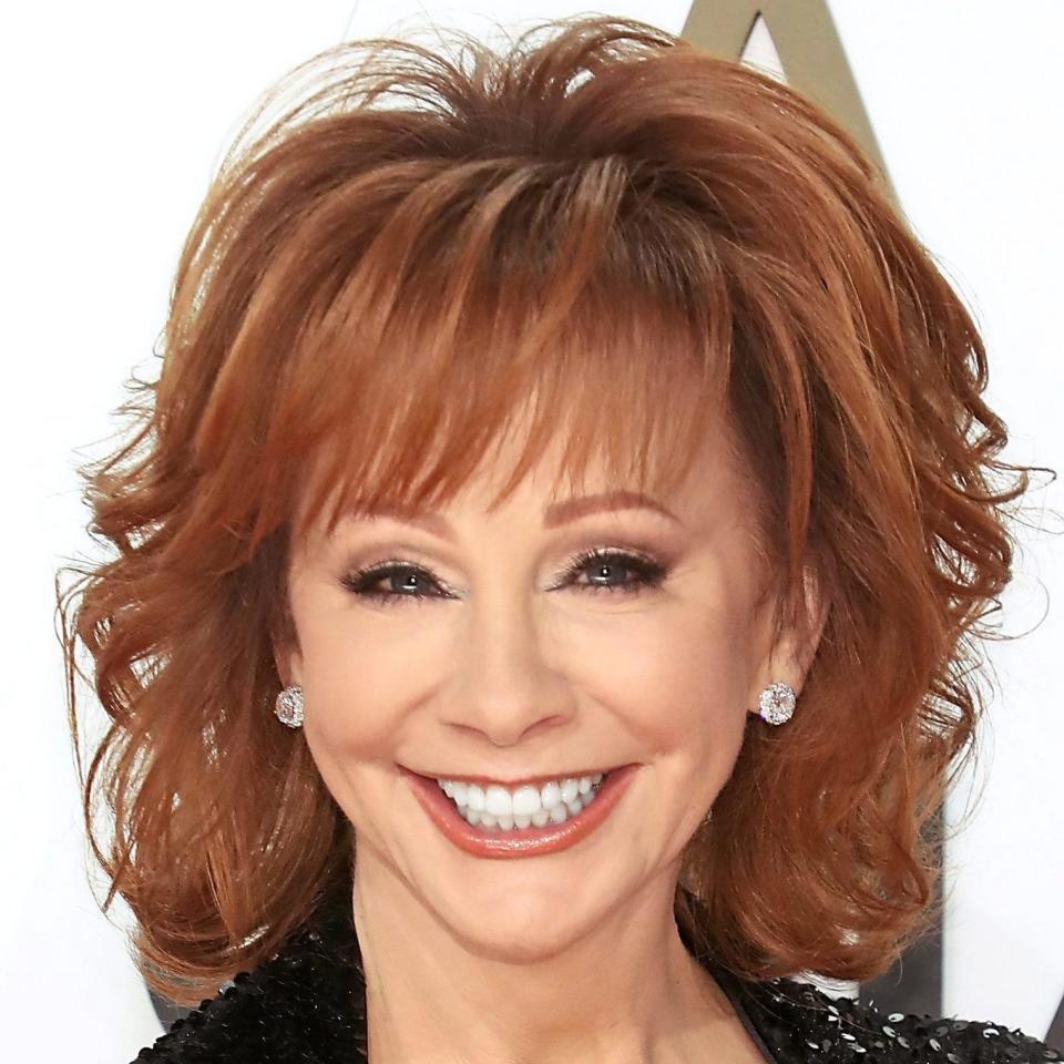 Reba McEntire smiling at camera with a shag hair cut